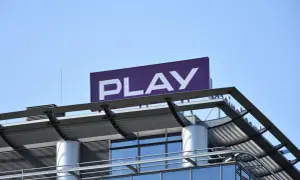 Logo PLAY na dachu budynku. Zastanawiasz się, co to roaming krajowy? To usługa, która pozwala korzystać z sieci innego operatora w Polsce.