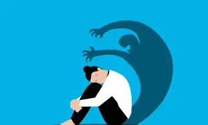 Una persona rannicchiata, oppressa da un'ombra minacciosa. Rappresentazione visiva dell'angoscia, il suo significato psicologico.