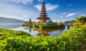 Świątynia Pura Ulun Danu Bratan na Bali podczas pory suchej. Woda spokojna, odbija wielopoziomową wieżę.