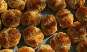 En person njuter av nybakade scones, gyllene och inbjudande.