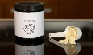 Barattolo di proteine in polvere e misurino con polvere. Le proteine sono fondamentali per la costruzione muscolare.