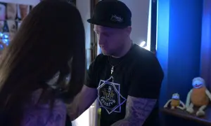 Artysta tatuażu rozmawia z klientką, która przygotowuje się do sesji. Może rozważa leki przeciwbólowe przed tatuażem, by zminimalizować dyskomfort.