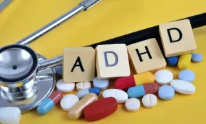 Stetoskop i tabletki symbolizujące leki na ADHD. Litery A, D, H, D ułożone obok.