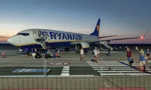 Ryanair przyloty Modlin: pasażerowie schodzą po schodkach z samolotu na płycie lotniska o zmierzchu.