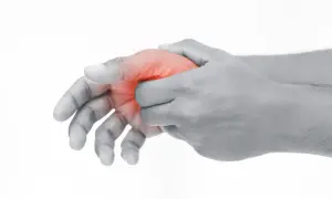 Schmerzende Hand, die den Daumen mit roter Markierung hält, was auf Schmerzen im Daumengelenk hinweist.