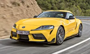 Żółta Toyota Supra pędzi po krętej drodze. Sprawdź aktualną toyota supra cena i poczuj moc!