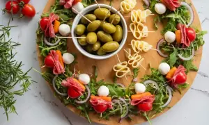 Oliwki, sery i przekąski z pomidorkami, mozzarellą i salami – idealne na 10 najlepszych sałatek na imprezę.