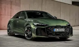 Elegancki, zielony Audi A5 Coupe z agresywnym grillem i sportowymi felgami, zaparkowany na drewnianej podłodze przy betonowej ścianie.