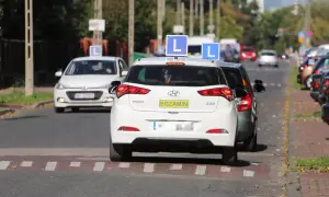 Samochody nauki jazdy z literą "L" na dachu i tabliczką "EGZAMIN" na tylnej klapie, kategoria a.