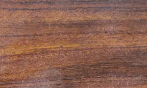 Textura rica de madera mongoy, con vetas oscuras y tonos dorados que evocan la naturaleza.