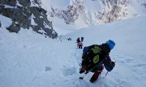 Grupa turystów wspina się po ośnieżonych zboczach. Nawet latem w Tatrach można spotkać takie widoki.