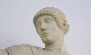 Buste en marbre d'Apollon, dieu grec ou romain, aux boucles caractéristiques et au regard pensif.