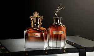 Dwa flakony perfum Jean Paul Gaultier Scandal Meski: jeden z koroną, drugi z nogami w szpilkach.