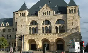 Imponujący zamek cesarski w Poznaniu, z kamienną fasadą i łukowymi oknami, przyciąga wzrok.