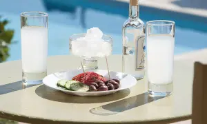Ouzo, grecki alkohol, podawany z oliwkami i ogórkiem, przy basenie, jak na wakacjach pod Partenonem.