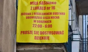 Żółty baner informuje miłą sąsiadkę z lokalu nr 16, że zgodnie z regulaminem budynku obowiązuje cisza nocna w godzinach 22:00-6:00.