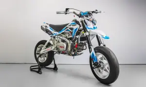 Biało-niebieski pit bike MRF Supermoto 140 na stojaku, z widocznym silnikiem Kayo.