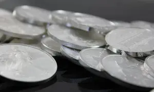 Stos monet bulionowych, symbol stabilnej srebro inwestycja. Błyszczące krążki z wizerunkami orłów i budowli.