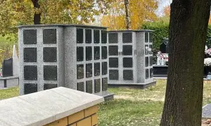 Kolumbarium i kwatera urnowa: różnica między nimi, koszty i estetyka. Dwa szare, granitowe kolumbaria z czarnymi tabliczkami na urny.