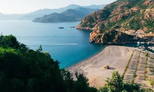 Malownicza zatoka z plażą i miasteczkiem, idealne miejsce na korsyka wczasy all inclusive.
