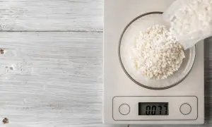 Balanza digital muestra 0.077 kg de arroz en un bol. Ideal para calcular cuánto arroz por persona.