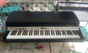 A vintage Fender Rhodes Stage Piano Mark I, a classic among labs vintage keys, sits on a teal metal stand outdoors.