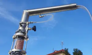 Metalowy destylator z wypełnieniem w szklanej kolumnie, gotowy do pracy. To właśnie destylator pozwala na oczyszczanie substancji.