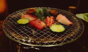 Kött och grönsaker grillas på en rund grill. Ett perfekt yakiniku recept för en mysig kväll.