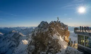 Sonnige Aussicht auf schneebedeckte Gipfel. Hier genießt man die meisten Sonnenstunden Deutschlands, umgeben von majestätischer Bergkulisse.