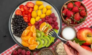 Kolorowa uczta dla ciała: truskawki, borówki, maliny, kumkwaty, kiwi i mandarynki. Idealna dieta warzywno owocowa na talerzu.