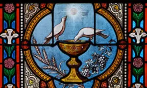 Witraż przedstawia kielich, z którego piją gołębice, symbolizujący święty graal. Obok kłosy i winogrona.
