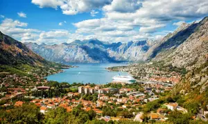 Bucht von Kotor, Montenegro: rote Dächer, Berge, Kreuzfahrtschiff. Entdecken Sie Montenegro Geheimtipps in dieser malerischen Kulisse.