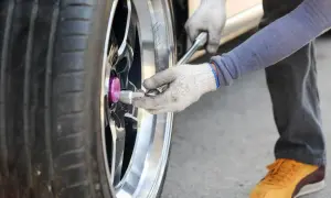Rękawiczki i klucz do kół pomagają prawidłowo ustawić klucz dynamometryczny do kół, dokręcając śruby.