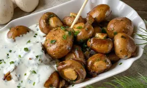 Gebratene Champignons mit cremiger Sauce und Schnittlauch – ein einfaches Gericht, das zu vielen Champignons Rezepten passt.