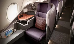 Luxuriöser Sitzbereich in der **besten Business Class** mit lila Ledersitzen, Kissen und einem Fenster.