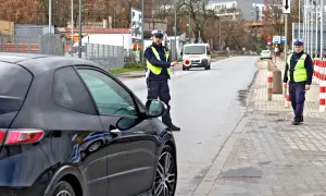 Policjant zatrzymuje czarne auto, być może kolejny mandat dla recydywisty.