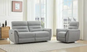 A grey recliner sofa and armchair in a bright living room with large windows.