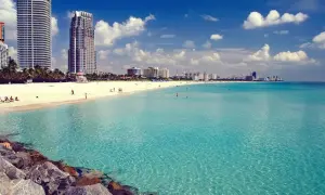 Traumhafter Strand in Miami mit türkisfarbenem Wasser und Wolken am Himmel. Perfekt für Ihre Miami Reisetipps!