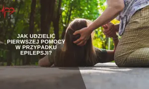 Starsza osoba pomaga osobie leżącej na ziemi, udzielając pierwszej pomocy w przypadku **epilepsji**.