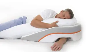 Man sleeping on his left side, using a wedge pillow designed to help with reflux.
