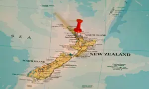 Czerwony pinezka zaznacza Nową Zelandię na mapie. To państwo wyspiarskie, które geograficznie należy do Oceanii, choć kulturowo i politycznie często kojarzone jest z Australią, która leży na kontynencie australijskim.