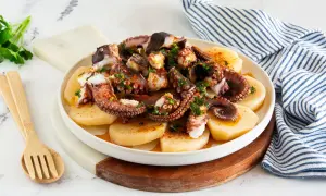Piatto di polpo alla gallega, con tentacoli succulenti su patate affettate, condito con paprika e prezzemolo fresco.