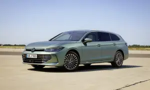 Nowy Volkswagen Passat B9 w kolorze zielonym, zaparkowany na betonowej nawierzchni, z błękitnym niebem w tle.