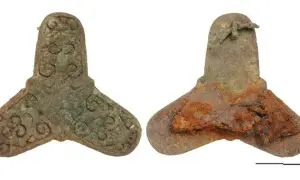Zwei bronzene Artefakte, ein gut erhaltenes mit Verzierungen, das andere stark verrostet, stammen aus einem Wikinger Grab.
