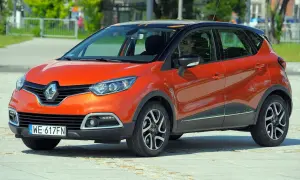 Pomarańczowy Renault Captur 2015 z czarnym dachem i pomarańczowymi akcentami stoi na placu.