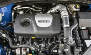 Silnik Kia Sportage 1.6 T-GDI z widocznym turbodoładowaniem i elementami układu dolotowego.
