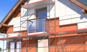 Dom w trakcie ocieplania styropianem, widoczne rusztowanie i fragment elewacji.