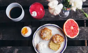 Frukost med kaffe, en rosa smoothie, ett kokt ägg, grapefrukt och nybakade mandelscones.