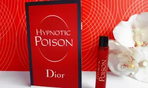 Kuszący zapach Christian Dior Hypnotic Poison w czerwonym flakonie obok karty z nazwą.