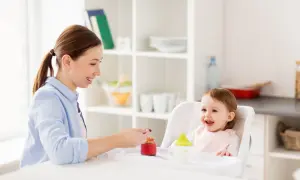 Mama karmi roczne dziecko, które z radością je. To pokazuje, ile powinno jeść roczne dziecko.